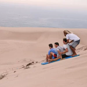 Sun House Morocco guests sandboarding the Tamri dunes