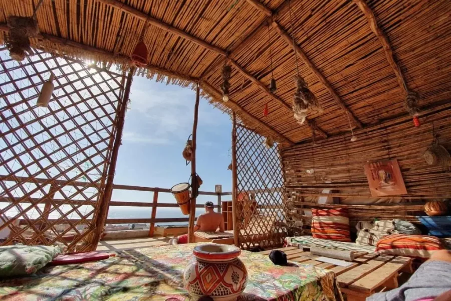 Interior of a wooden terrace at Imsouane Soul Lodge showing traditional pottery and coastal views.