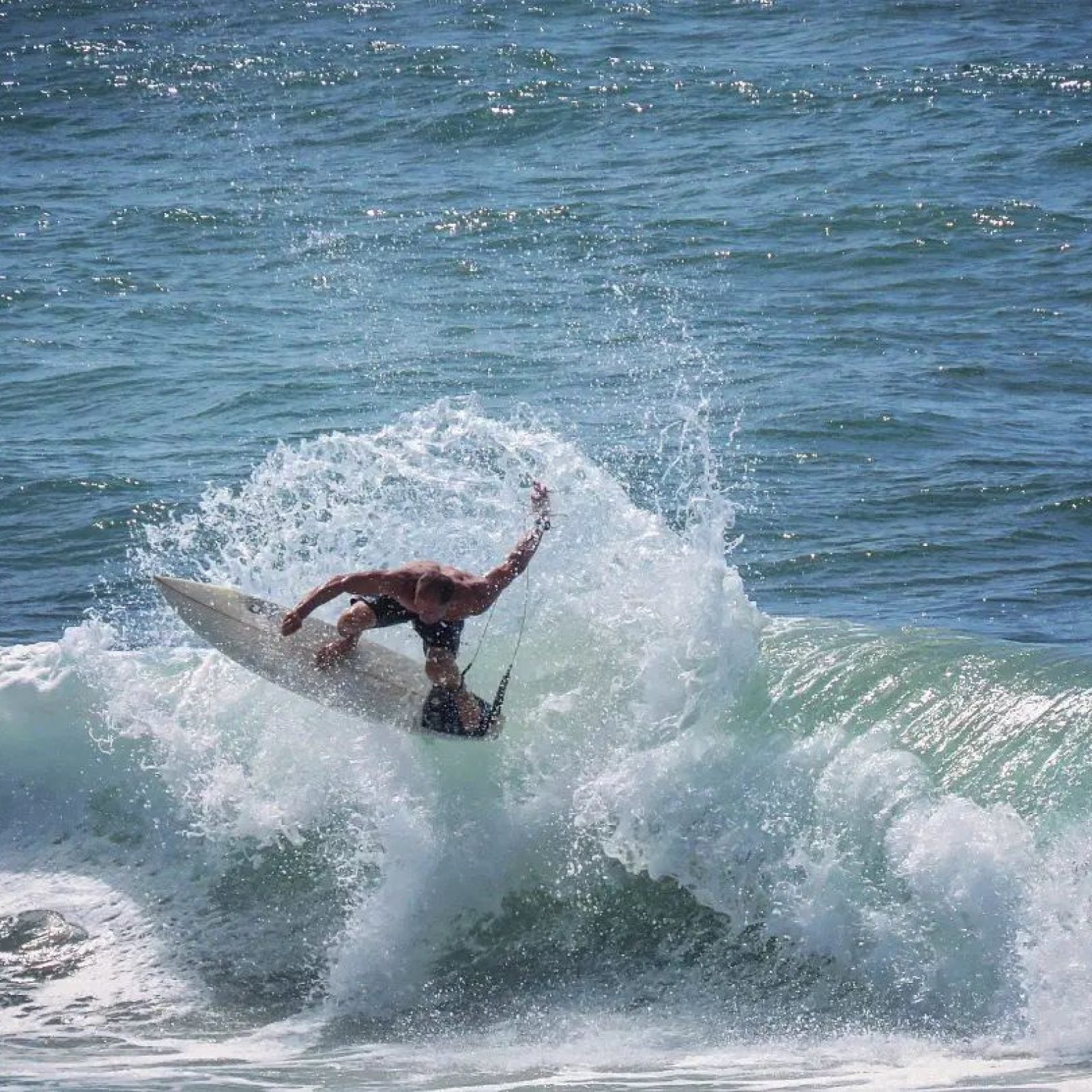 A surfer performs a front-side turn on a chest-high wave at Jack Beach in Casablanca.
