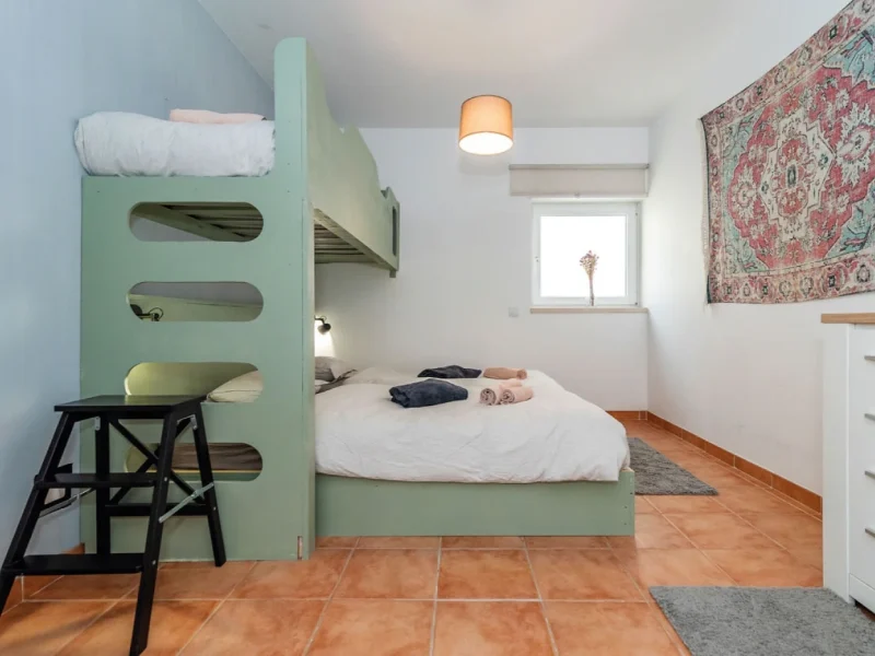 Standard 3 Room bedroom at SURFinn Figueira da Foz featuring mint green bunk bed frame with lower bed and overhead storage, work desk with stool, and terracotta tiled flooring.