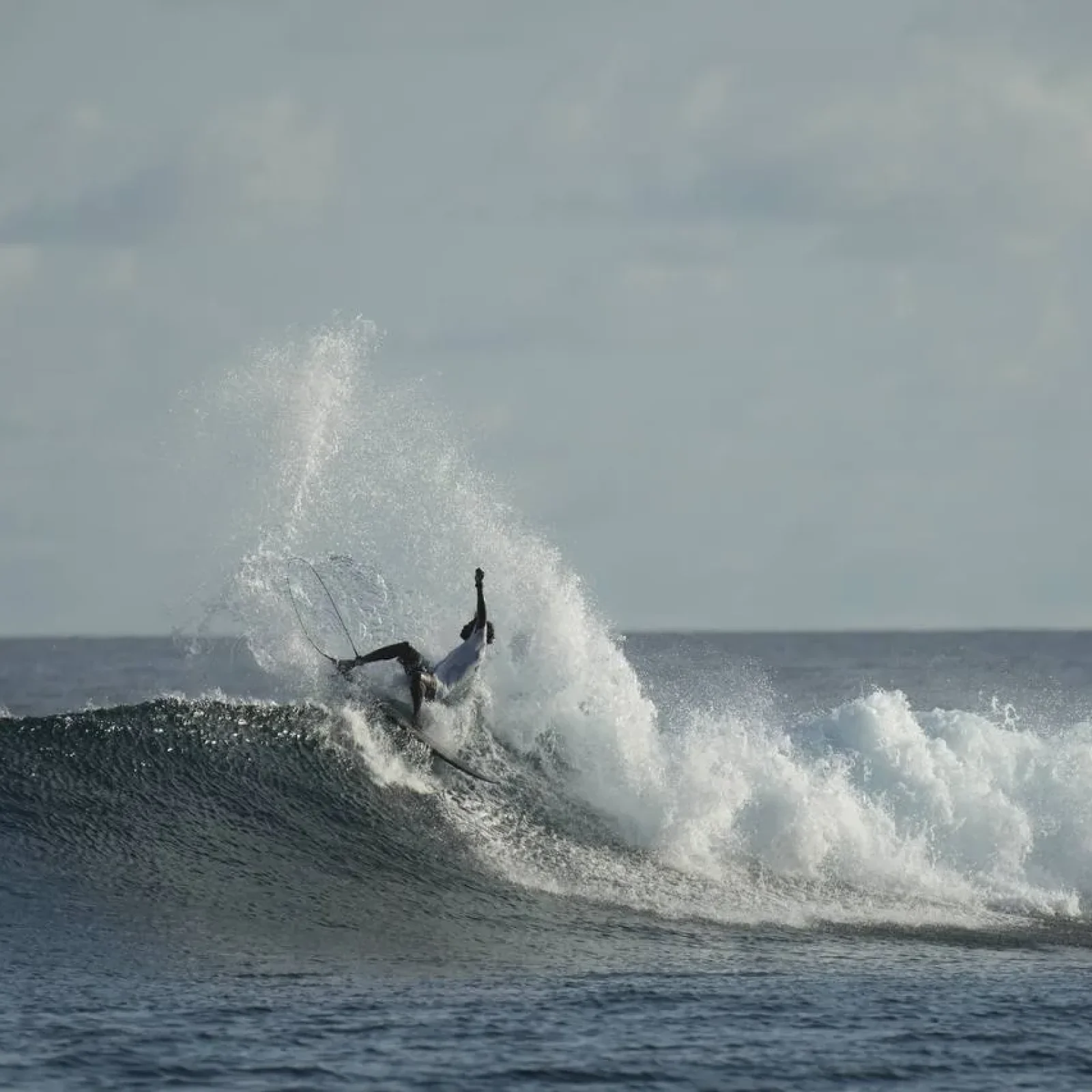 Surfeur surfant une grande vague à l'Oceana Inn Maldives - Surf Camp Kudahuvadhoo aux Maldives.