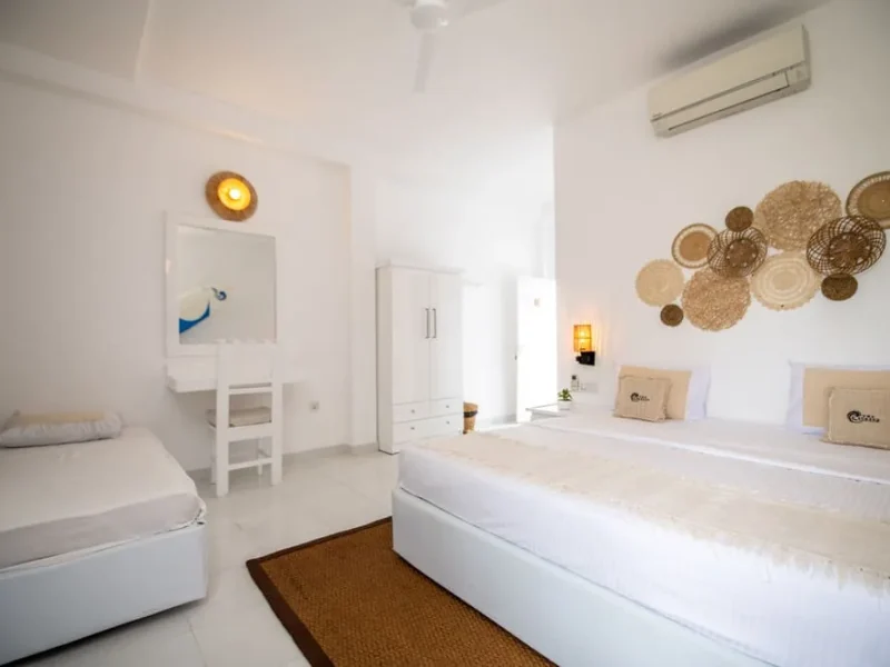 Private triple room at The Surfer Beach Camp Weligama with white walls, double bed, and coastal décor.