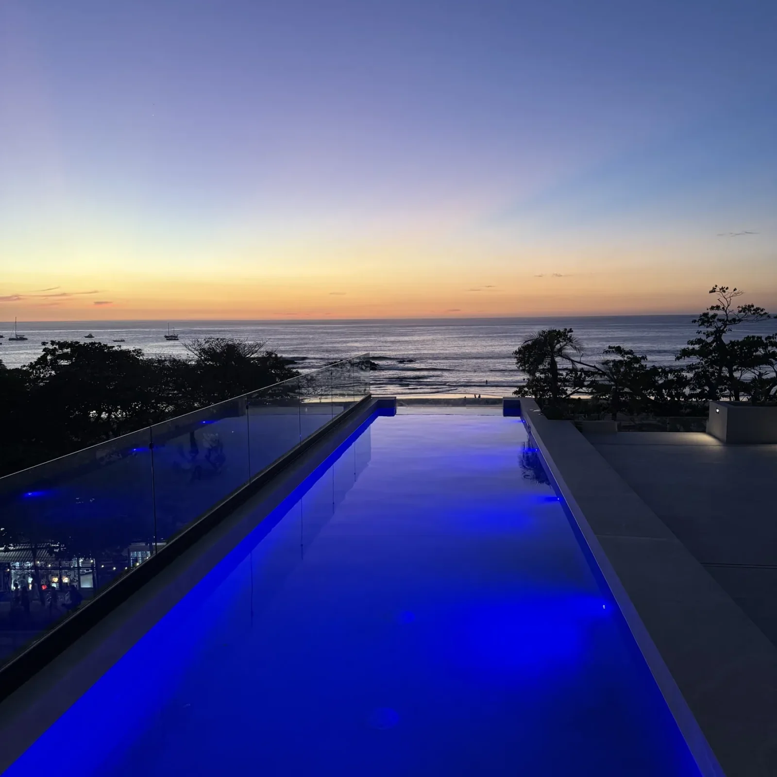 Rooftop infinity pool with LED lighting at sunset, Iguana Surf Tamarindo