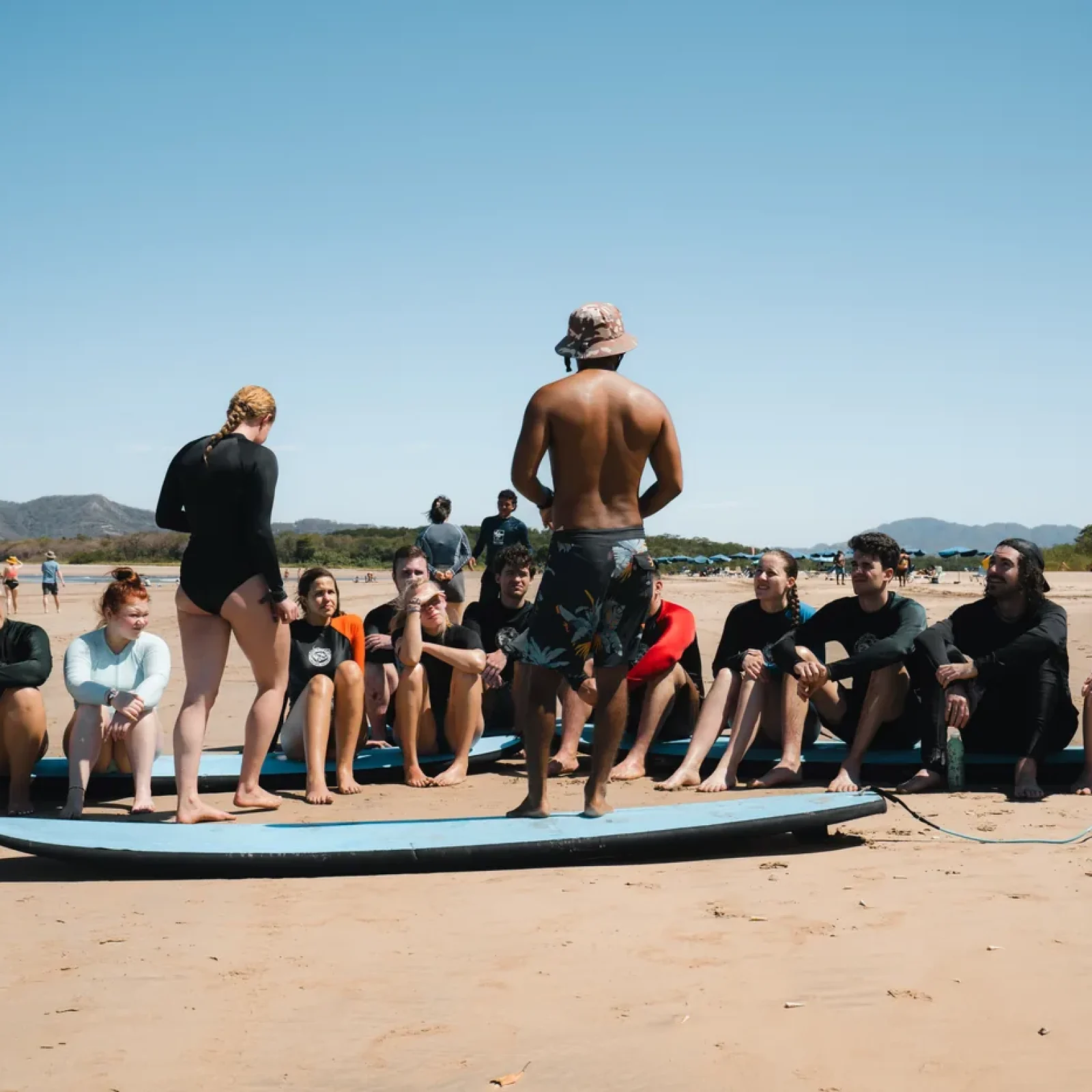 Iguana Surf instructor briefing students on Tamarindo beach before a surf lesson