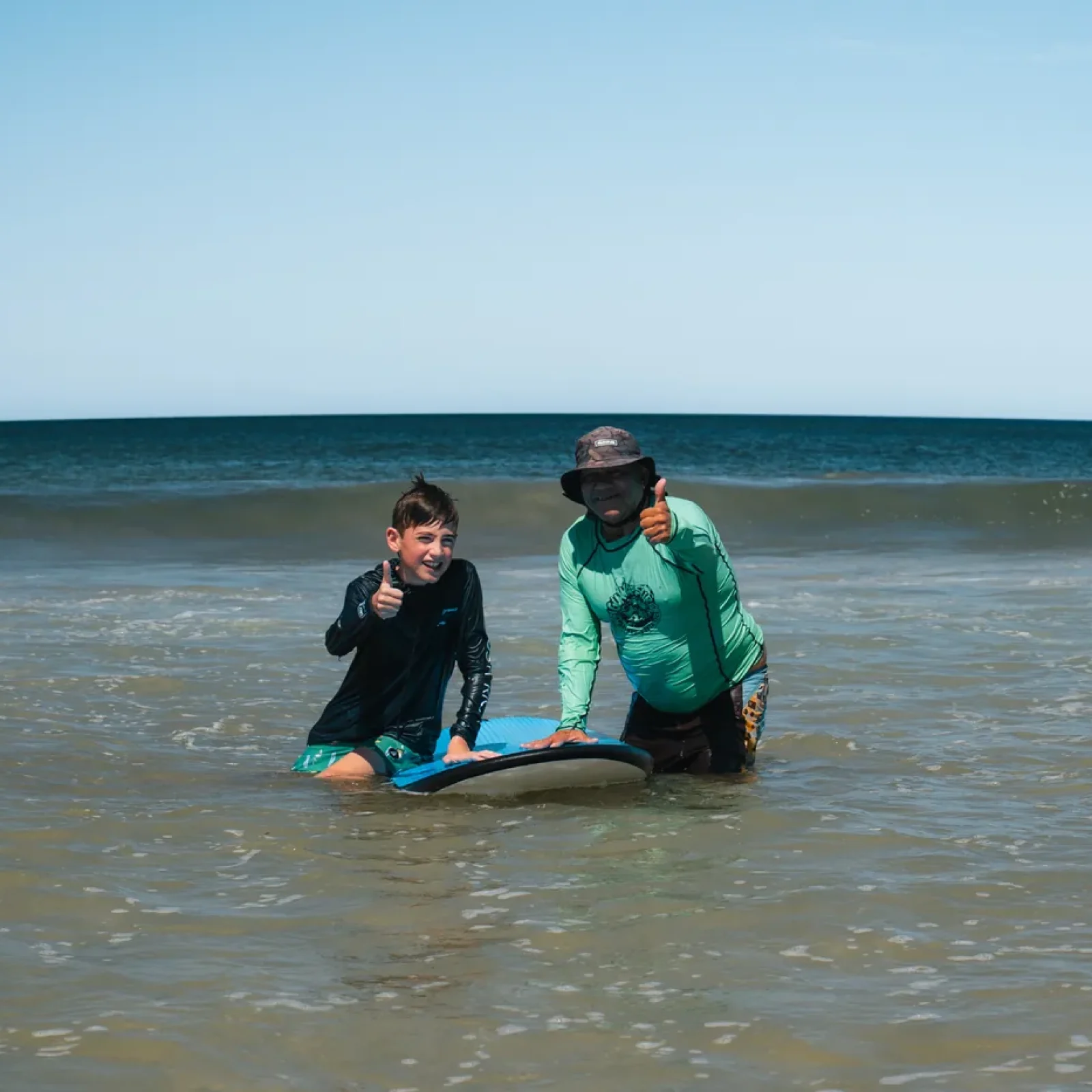 Young surf student and Iguana Surf instructor in the water at Tamarindo